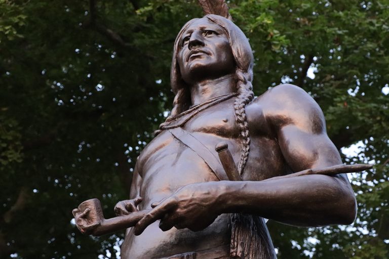 A detailed close-up of the Massasoit statue by Cyrus Edwin Dallin captured from a low angle.